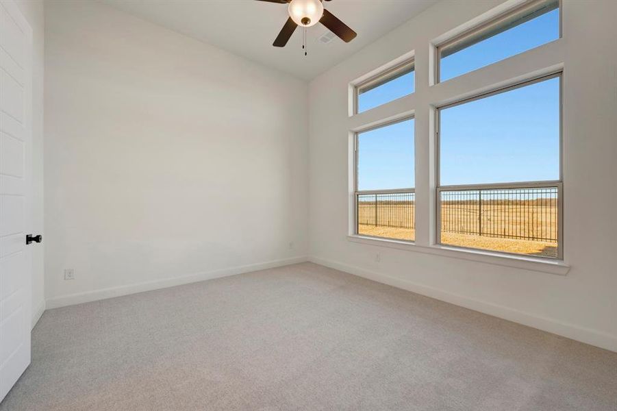 Unfurnished room featuring light carpet and a ceiling fan Unfurnished room featuring light carpet and a ceiling fan