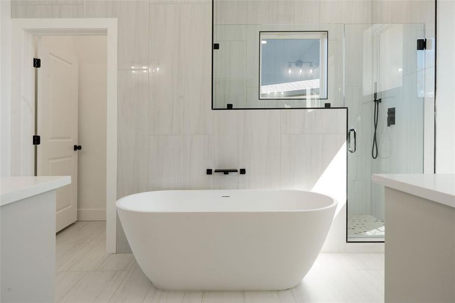 Bathroom with vanity, a stall shower, tile walls, and a freestanding bath