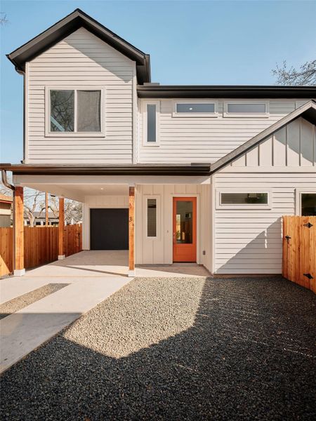 View of front of home with board and batten siding, an attached garage, and driveway