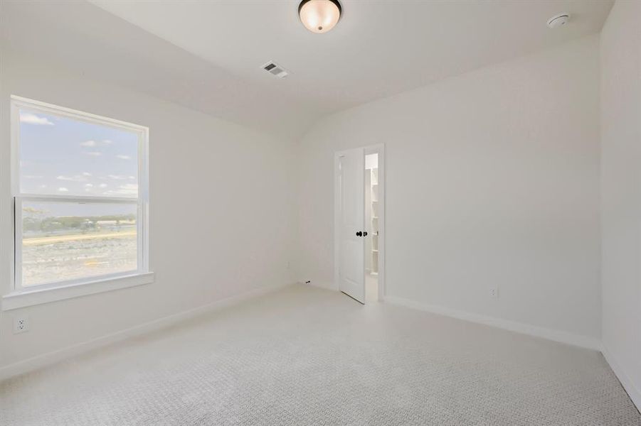 Carpeted room with a double-hung window, white trim, and a ceiling-mounted light fixture