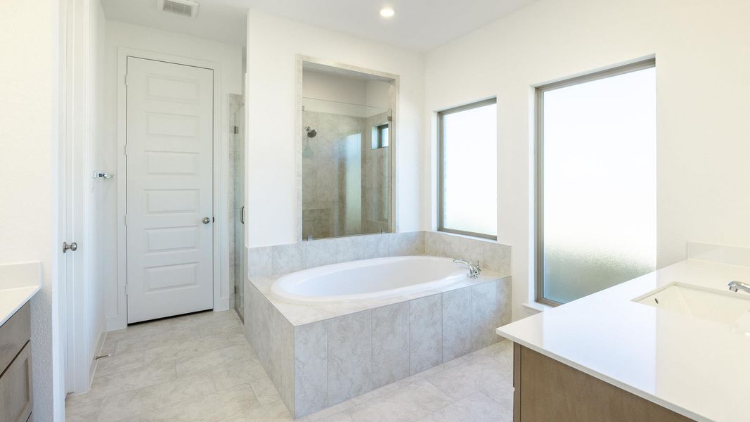 Full bathroom featuring vanity, a shower stall, a bath, and recessed lighting