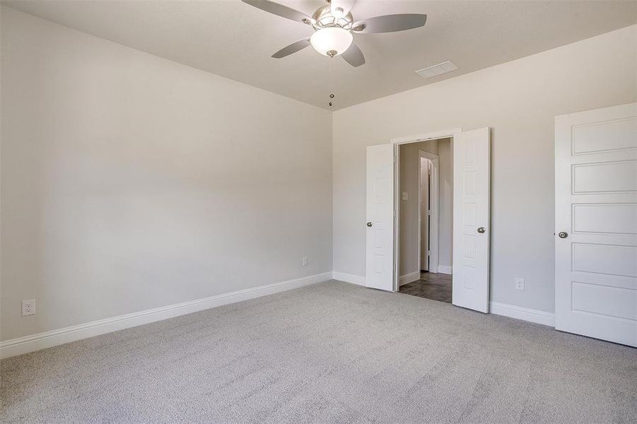 Unfurnished bedroom featuring carpet floors and ceiling fan