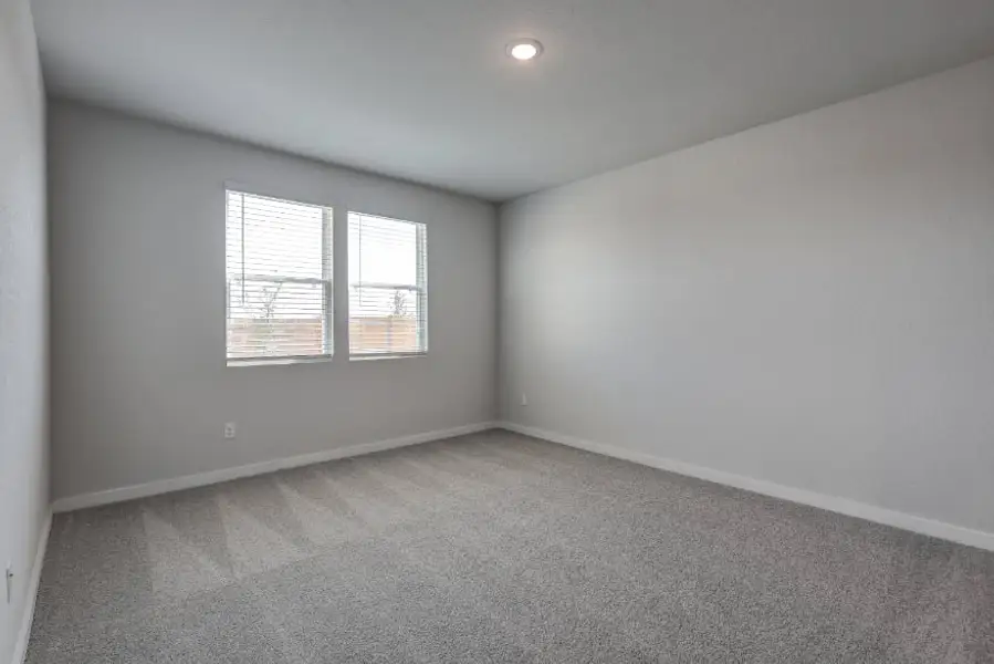 A room with a window and a carpet.