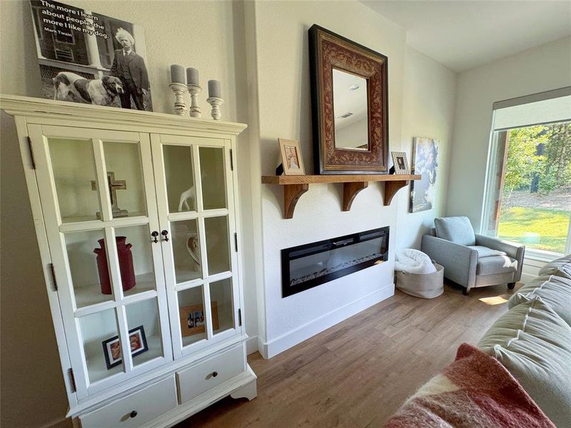 Living room featuring a glass covered fireplace and dark wood-style floors Living room featuring a glass covered fireplace and dark wood-style floors