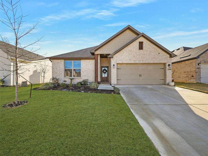 View of front of house with a front yard and a garage