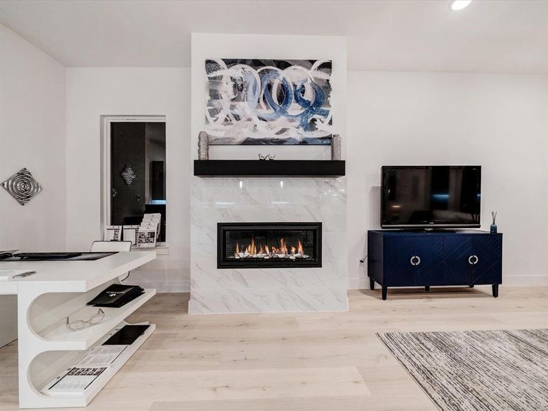 Living room featuring a high end fireplace, light wood-style floors, and recessed lighting Living room featuring a high end fireplace, light wood-style floors, and recessed lighting