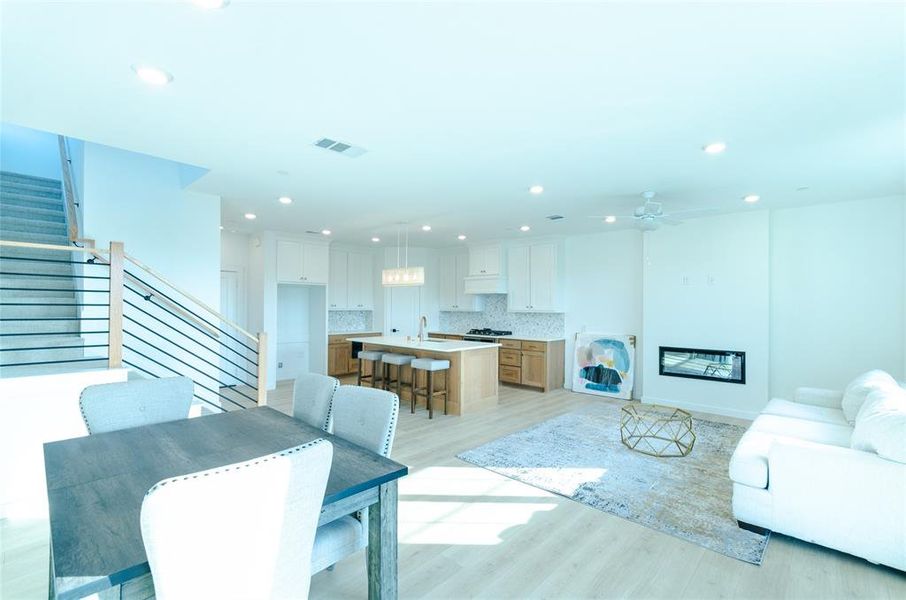 Living room featuring stairway, light wood-style flooring, recessed lighting, and ceiling fan