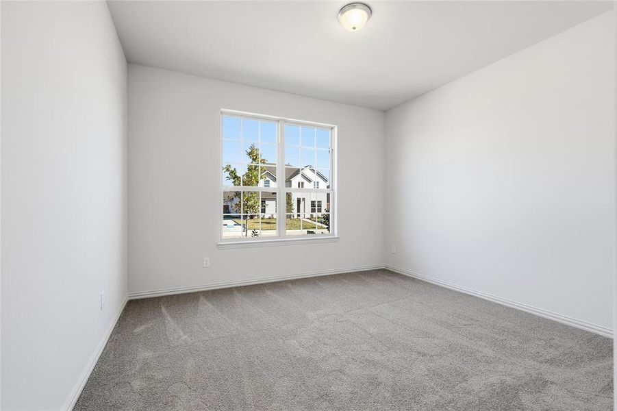 Empty room with light colored carpet and baseboards