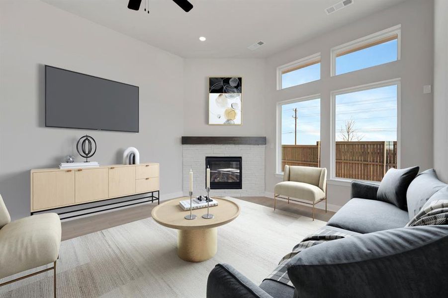 Living area with a glass covered fireplace, light wood finished floors, a ceiling fan, and recessed lighting Living area with a glass covered fireplace, light wood finished floors, a ceiling fan, and recessed lighting