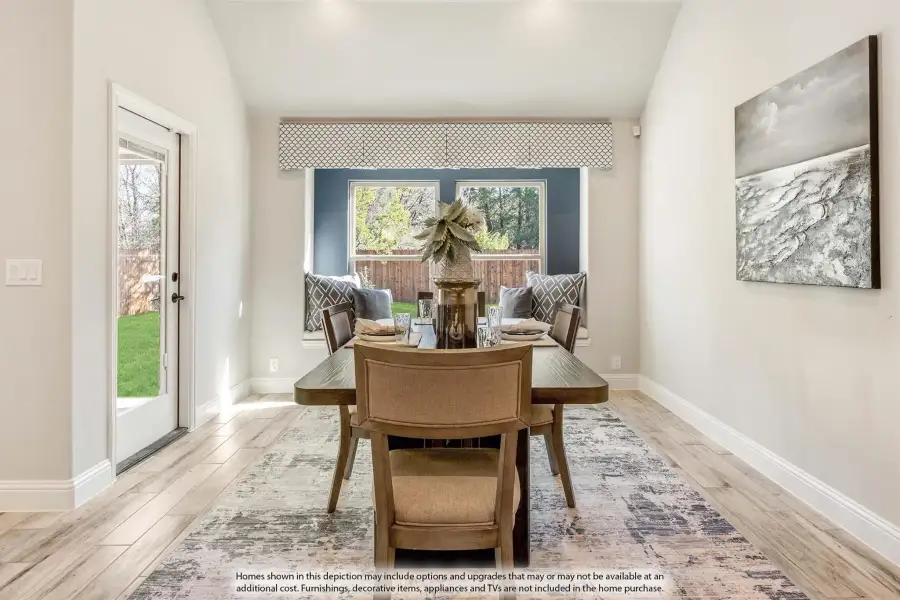 Dining room with wood table, built-in bench seating, large windows, and light hardwood floors