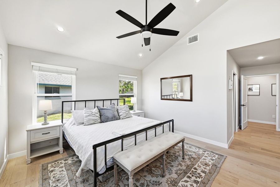 Bedroom with lofted ceiling, light wood-type flooring, a ceiling fan, and recessed lighting