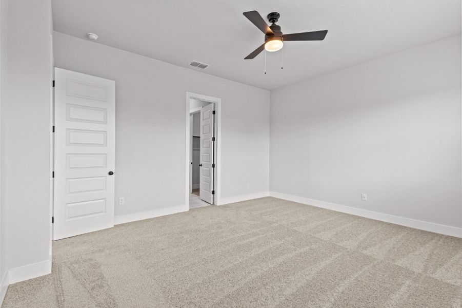 A room with a ceiling fan and a door.