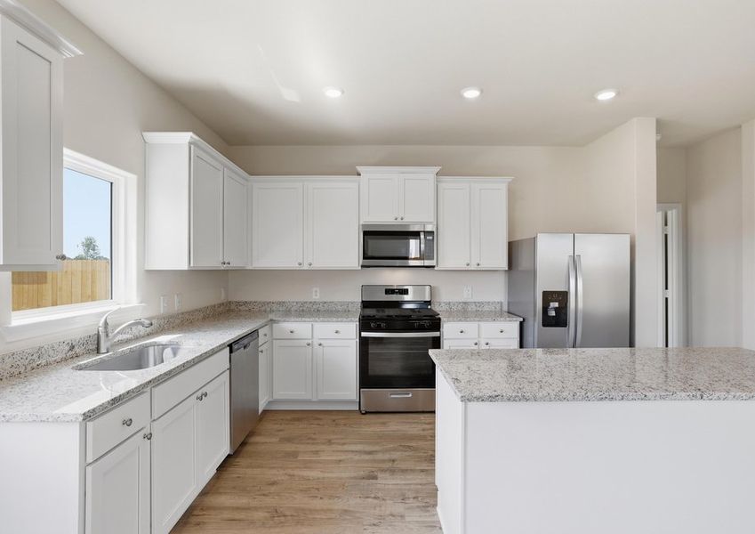 Kitchen featuring a white island, granite countertops, and stainless steel appliances.