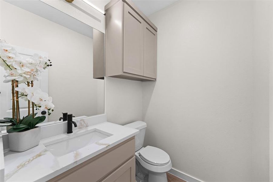 Contemporary bathroom vanity featuring a rectangular undermount sink, a quartz countertop with subtle veining, and a matte black single-handle faucet Contemporary bathroom vanity featuring a rectangular undermount sink, a quartz countertop with subtle veining, and a matte black single-handle faucet