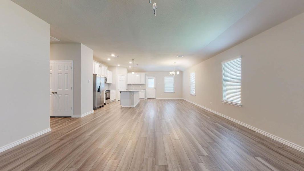 Expansive living area featuring wood-finish flooring, recessed lighting, and a neutral color palette