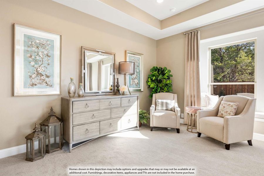 Bedroom sitting area with tray ceiling, dresser with mirror, two accent chairs, and large window with neutral carpet