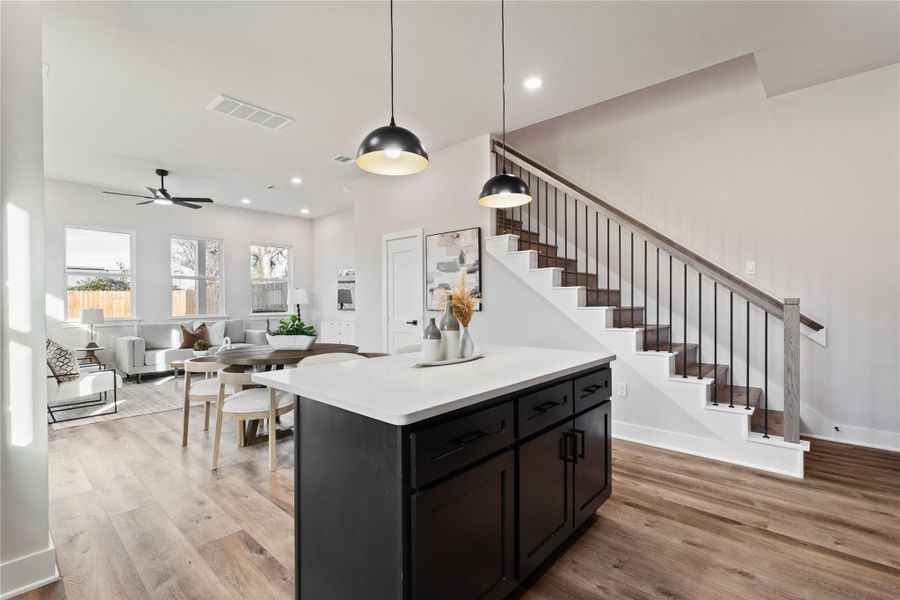 The heart of the home shines with a large island and an open layout that connects every space with ease. With soaring ceilings, designer lighting, and a smooth flow into the living area, this home feels both elevated and comfortable.