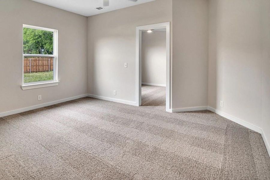 Carpeted empty room with baseboards and a ceiling fan Carpeted empty room with baseboards and a ceiling fan