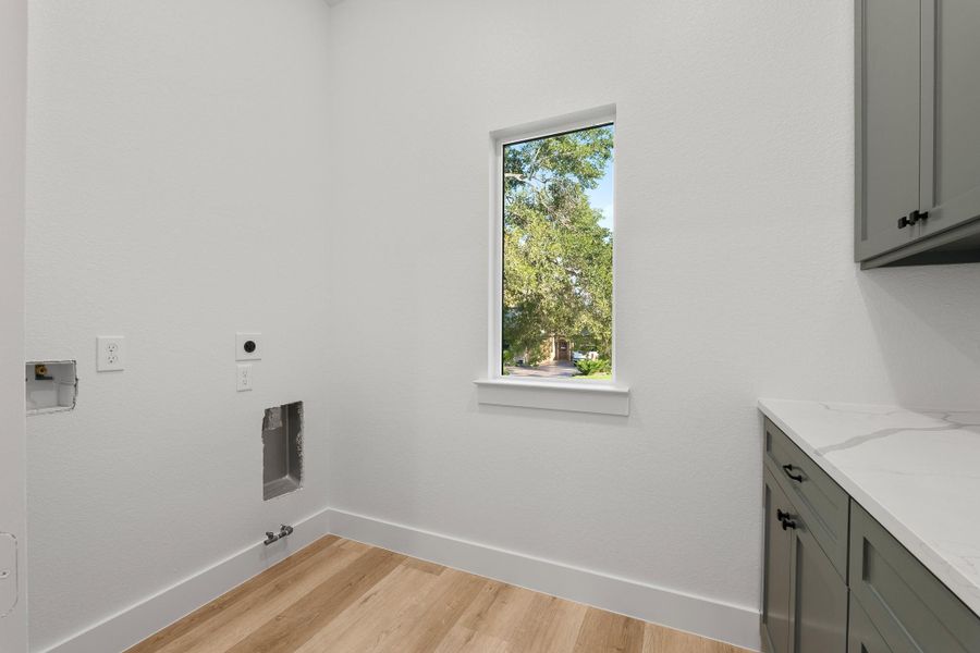 Elegant downstairs laundry room with custom cabinets and quartz countertops. Elegant downstairs laundry room with custom cabinets and quartz countertops.