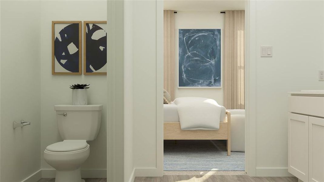 Bathroom featuring wood-type flooring, vanity, and toilet