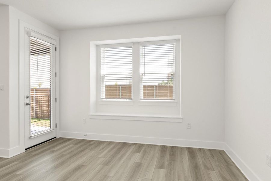 Spare room featuring light wood-style floors and healthy amount of natural light