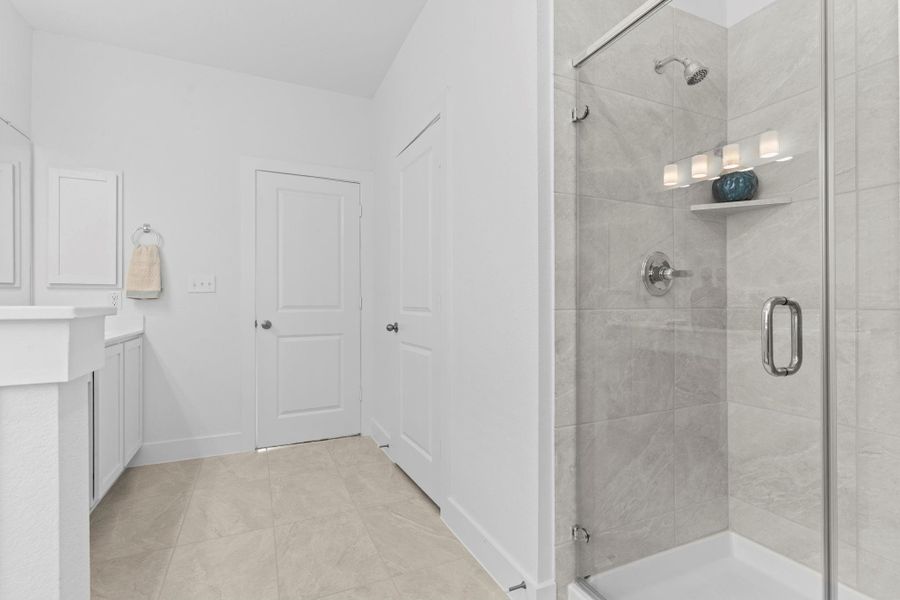 A clear view of the spacious walk-in shower featuring a sleek frameless glass door and neutral tile surround—seamlessly blending luxury and everyday functionality. **Image Representative of Plan Only and May Vary as Built**.