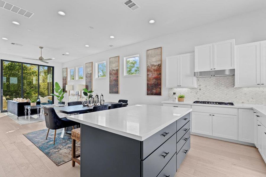 Kitchen featuring white cabinetry, a kitchen breakfast bar, a kitchen island, and recessed lighting