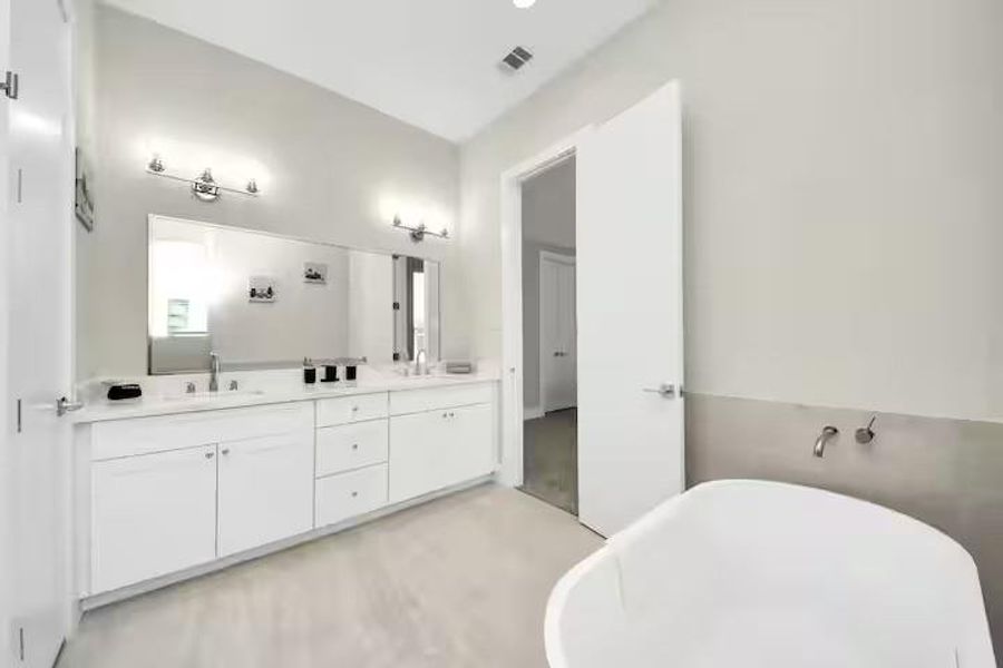 Start and end the day with room to spread out. The primary bath offers an extended vanity, generous storage, and a freestanding soaking tub.
