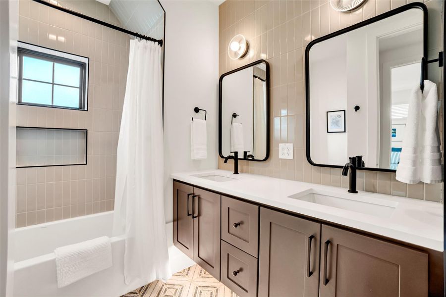 Full bath featuring shower / tub combo, double vanity, and light flooring Full bath featuring shower / tub combo, double vanity, and light flooring