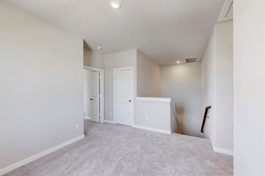 Spare room with light carpet and recessed lighting