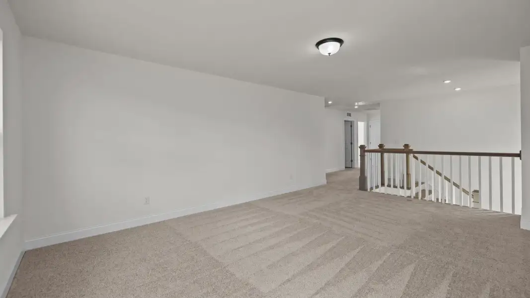 Spacious loft with plush carpeting, elevated ceiling and open rails, in the Norris Design by DRB Homes in York, SC Spacious loft with plush carpeting, elevated ceiling and open rails, in the Norris Design by DRB Homes in York, SC