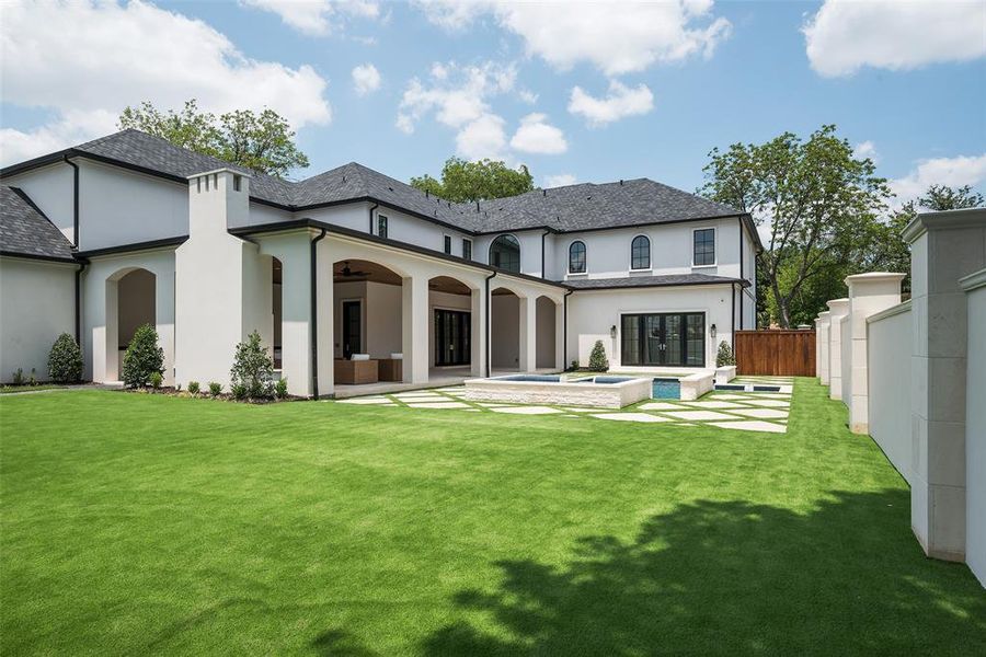 Rear view of house with an in ground hot tub, a patio, a yard, and ceiling fan