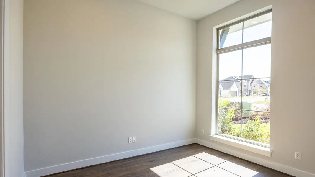 Unfurnished room featuring baseboards and dark wood-type flooring