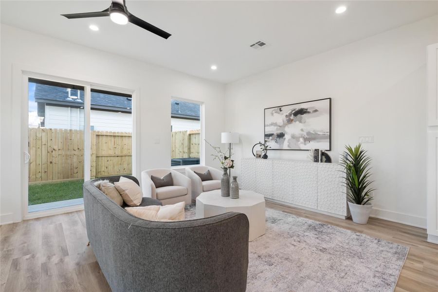 The living room is spacious and inviting, perfect for relaxing or entertaining. Its open layout and abundant natural light create a warm, airy atmosphere. This central gathering space blends comfort and style, making it the heart of the home.