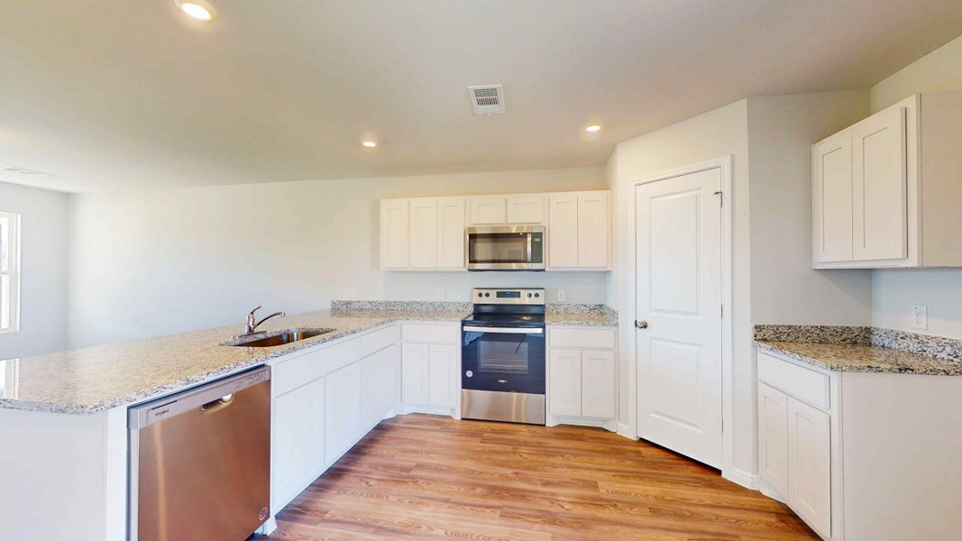 A kitchen with white cabinets.