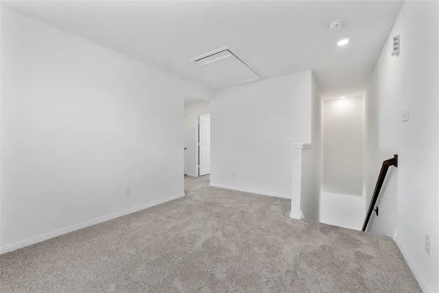 Another perspective of the Loft, showcasing the staircase and hallway leading to the secondary bedrooms. Another perspective of the Loft, showcasing the staircase and hallway leading to the secondary bedrooms.