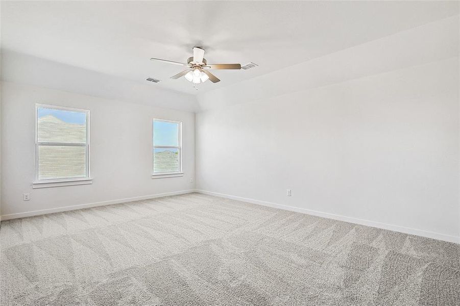 Carpeted spare room with ceiling fan