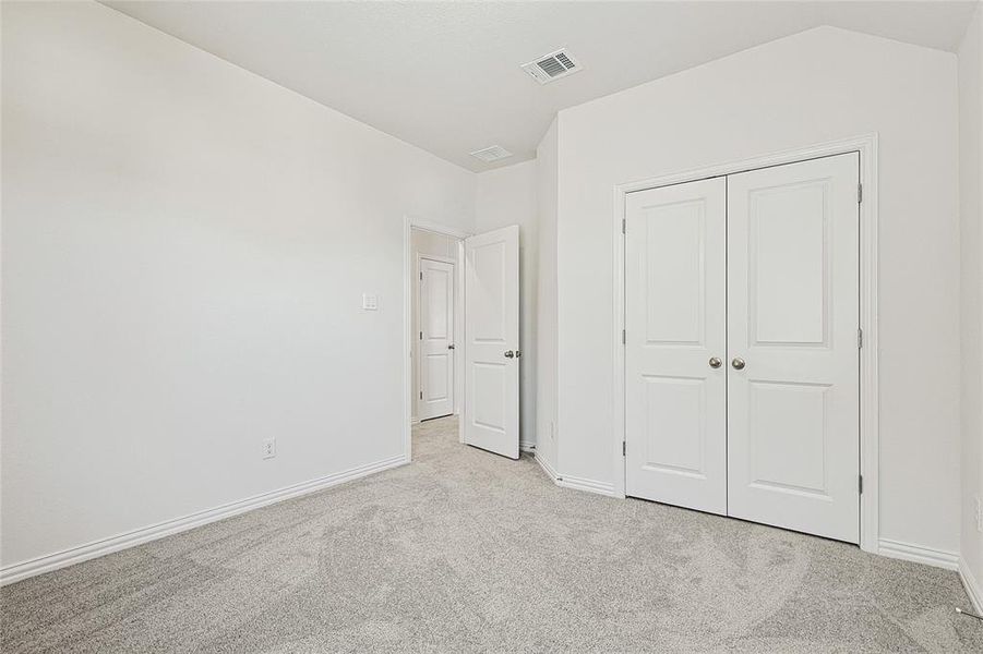 Unfurnished bedroom with carpet floors and a closet Unfurnished bedroom with carpet floors and a closet