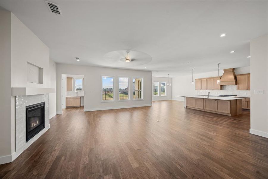 Unfurnished living room featuring a tiled fireplace, dark wood-style flooring, recessed lighting, and a ceiling fan
