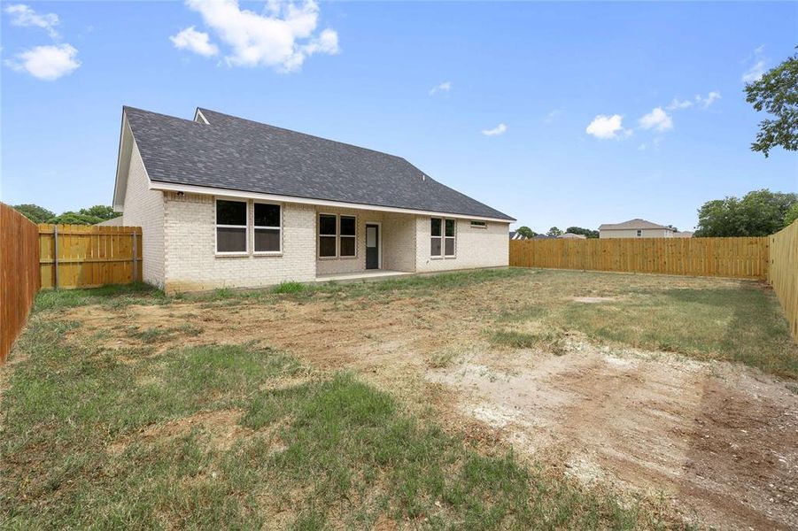Rear view of property featuring a patio area, a fenced backyard, a shingled roof, and brick siding Rear view of property featuring a patio area, a fenced backyard, a shingled roof, and brick siding