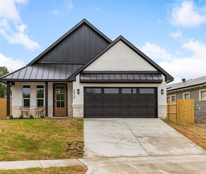 View of front of house featuring a garage, a porch, and a front yard