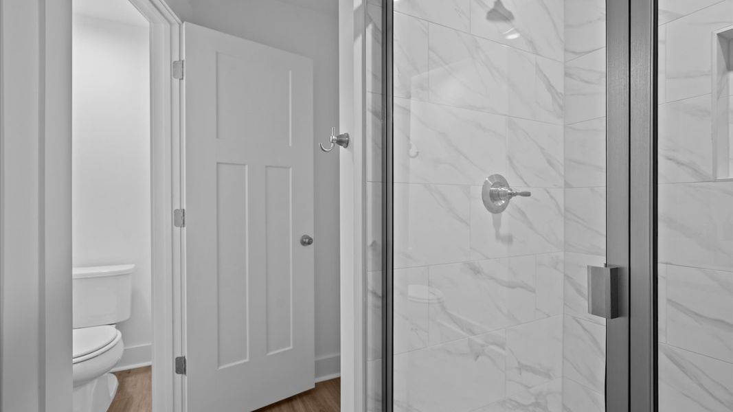 Elegant primary bathroom featuring a spacious walk-in shower and dual vanity in this first-class DRB Homes design Elegant primary bathroom featuring a spacious walk-in shower and dual vanity in this first-class DRB Homes design