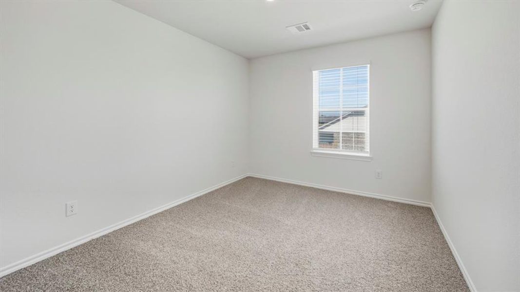 Carpeted spare room featuring baseboards