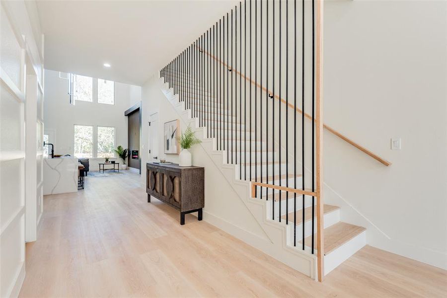 Staircase with hardwood / wood-style flooring and a towering ceiling