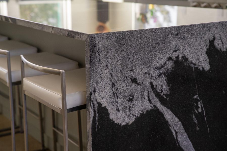 The heart of the home is defined by a stunning waterfall island, where the quartz flows seamlessly to the floor. The sleek, overhanging edge provides the perfect spot to slide in barstools, creating an inviting space for morning coffee or casual evening entertaining.