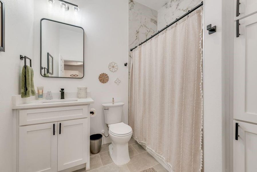 Full bathroom featuring vanity, a shower with curtain, and light tile patterned floors