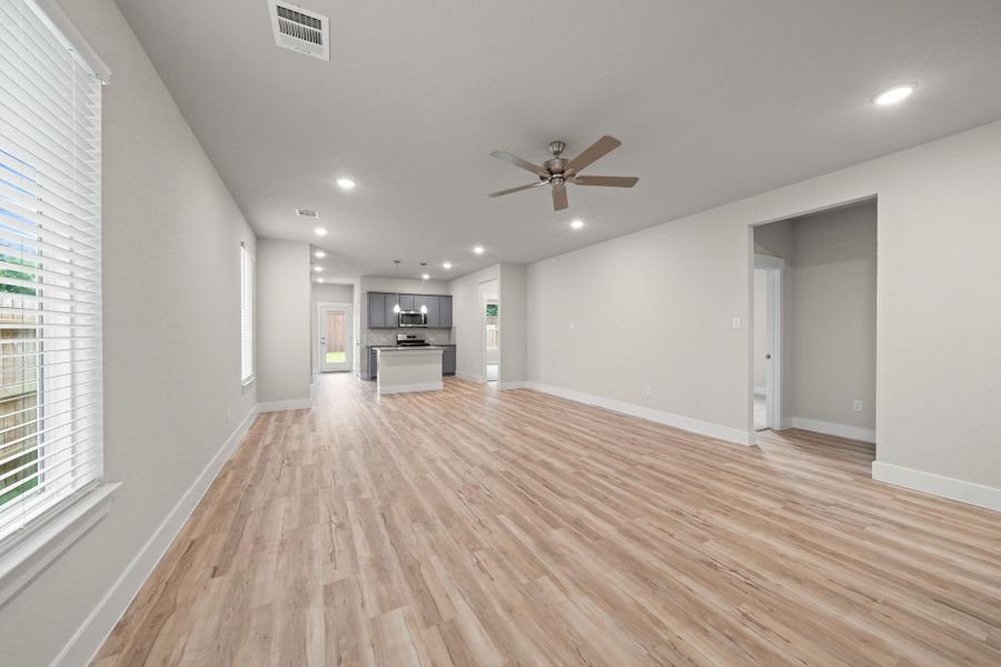 Step into comfort and elegance with this spacious, light-filled living room, perfect for relaxing or entertaining guests. Featuring beautiful wood-look vinyl plank flooring, fresh neutral paint, and modern recessed lighting throughout, this space feels both cozy and contemporary.