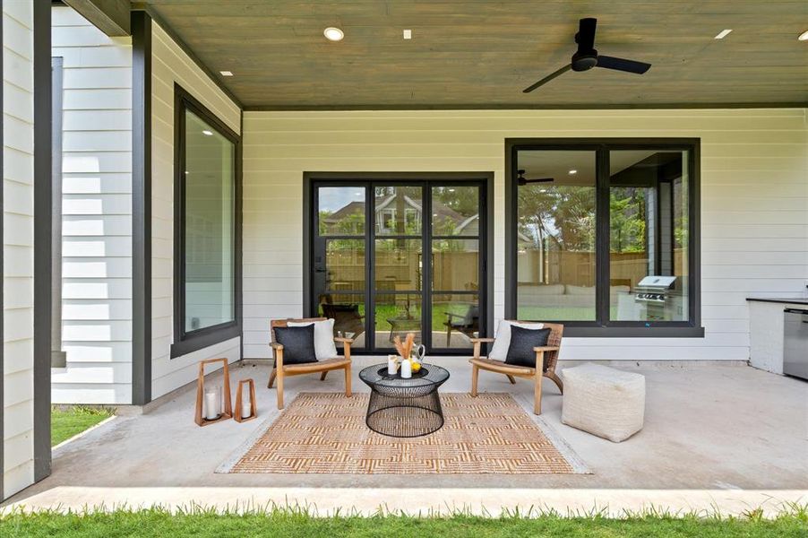 Large covered outdoor patio with built-in gas grill and beverage cooler.