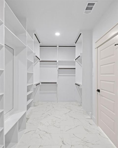 Spacious closet featuring marble finish floor and visible vents