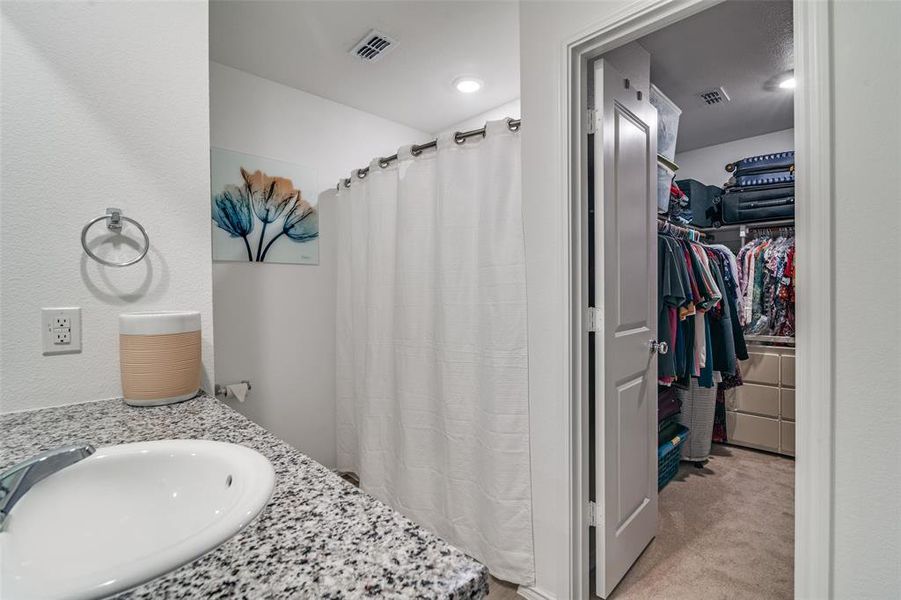 Bathroom with sink and curtained shower